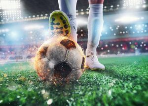 close up of soccer striker ready to kicks the fiery ball at the stadium 1